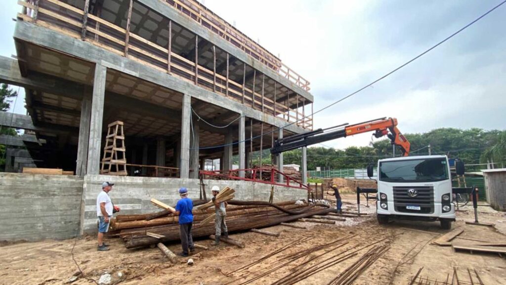 Prédio em construção com trabalhadores e guindaste ao redor